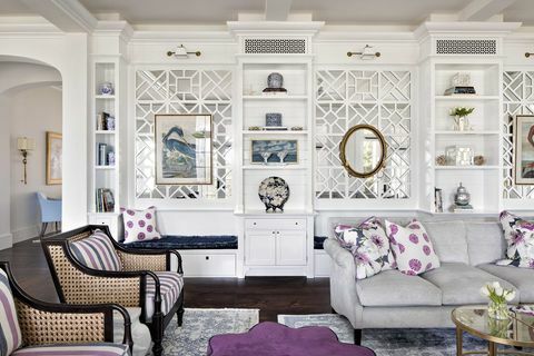 sufragerie, canapea gri, perne decorative mov si alb, dulapuri de depozitare albe, pouf mov