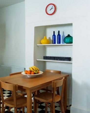idei de alcovă, masă simplă din lemn și scaune în bucătăria modernă albă cu pardoseală din negru alb