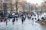 Patinatorii de gheață alunecă peste canalele înghețate din Amsterdam în timpul înghețării mari a Europei