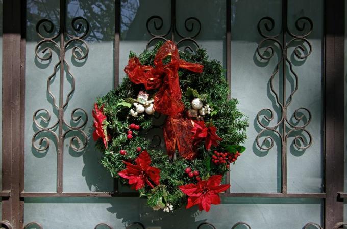 coroană de Crăciun pe o ușă elegantă din fier forjat și sticlă mată