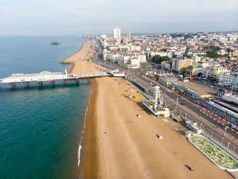 fotografie aeriană a celebrului debarcader și ocean Brighton situat pe coasta de sud a Angliei, Marea Britanie, care face parte din orașul Brighton and Hove, realizat într-o zi însorită strălucitoare, care arată plimbările din târg.