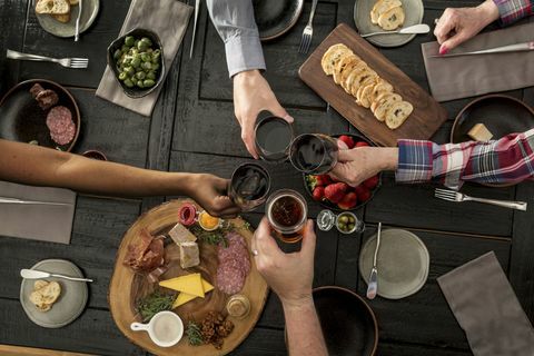 Vedere deasupra prietenilor care împărtășesc o masă: prietenii care împărtășesc charcuterie și tapas cu vin și bere.