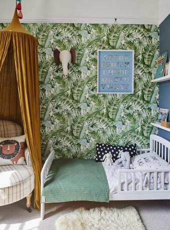 dormitor copii cu tapet imprimeu palmier tropical si baldachin galben