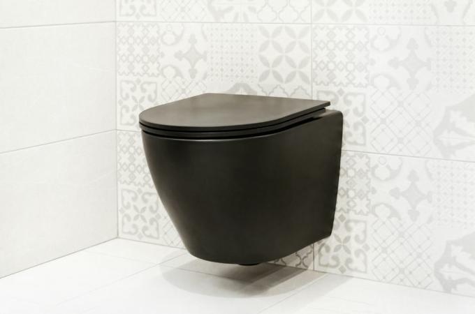 WC suspendat negru pe perete alb WC modern montat pe perete intr-o baie cu gresie