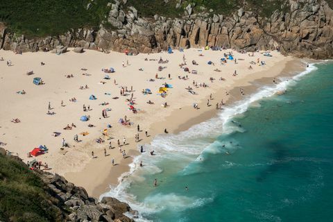 Vizitatorii se apucă de soare pe plaja Porthcurno, lângă Penzance, pe 28 iunie 2018.