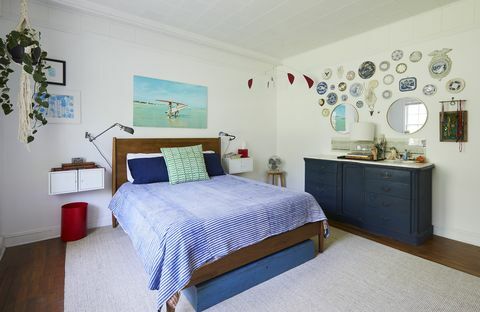 dormitor principal, lenjerie albastră, cadru de pat din lemn, dulapuri albastre, perete galerie, farfurii suspendate