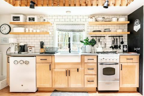 bucătărie completă în cabină cu dulapuri din lemn și detalii albe și negre