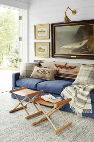 living rustic cu canapea albastră, scaune din piele și lucrări de pește