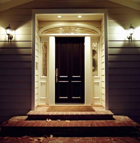 Ușa din față a casei cu lumini noaptea